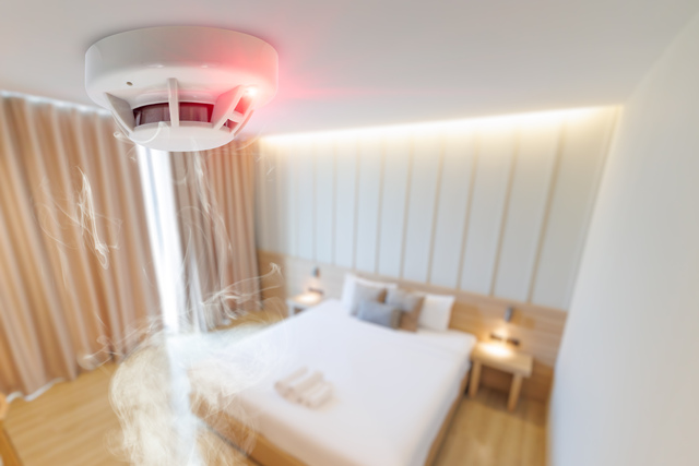 hotel bad room smoke fire detector install at ceiling. fire safety device for home
